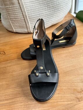 Louise et Cie Black T-Strap Flat Sandals with Gold Accents - 9.5